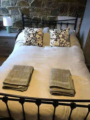 a bed with two pillows and towels on it at The Eagles Inn in Rhayader