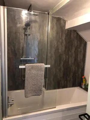 a shower with a glass door next to a bath tub at The Eagles Inn in Rhayader