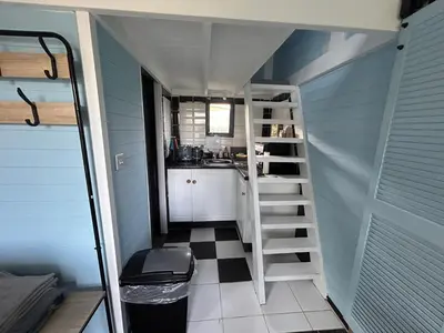 a small kitchen with a staircase in a tiny house at Bon yr Llew, Coity Bach in Brecon