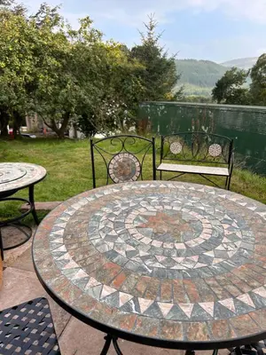a patio with a table and two chairs and a table and chairs at Bon yr Llew, Coity Bach in Brecon