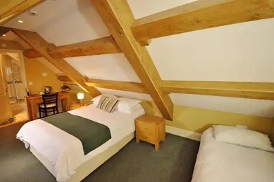 a bedroom with a bed and a desk in a room at The Castle Hotel in Talgarth