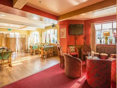 a dining room with red walls and a table and chairs at The Castle Hotel in Talgarth
