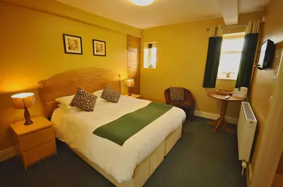 a hotel room with a large bed and a window at The Castle Hotel in Talgarth