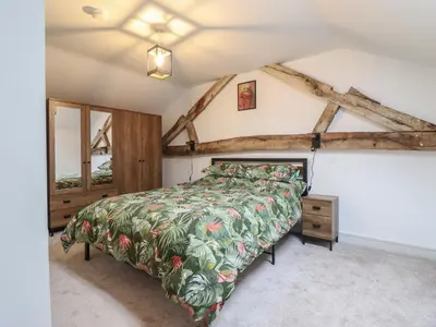 a bedroom with a bed and a wooden ceiling at Sally's Barn in Oswestry
