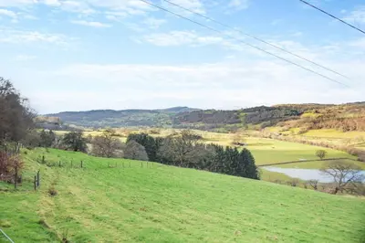 a grassy hill with a lake in the distance at 1 Bed in Llandderfel oc-t30475 in Llandderfel