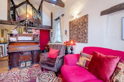a living room with a red couch and a piano at 1 Bed in Llandderfel oc-t30475 in Llandderfel