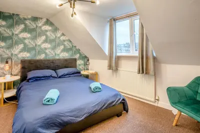 a bedroom with a bed and a green chair at 4 Bed in Brecon oc-h30823 in Brecon