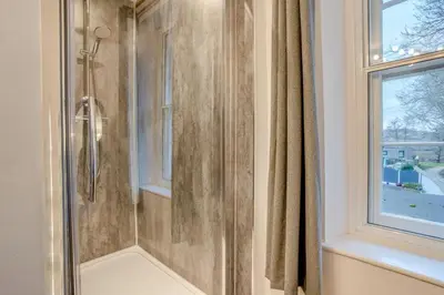 a shower with a glass door next to a window at 4 Bed in Brecon oc-h30823 in Brecon