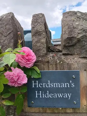 a sign with pink flowers in front of a building at Herdsman's Hideaway in Leominster