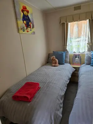 two beds in a bedroom with a teddy bear on it at Homely 2 Bedrommed Mobile Home E1 in Aberystwyth