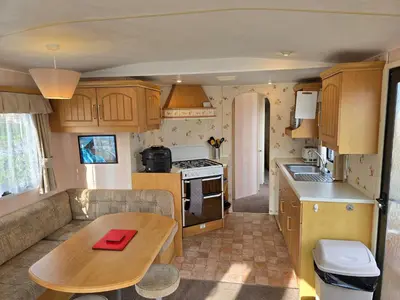 a kitchen with a couch and a table in a caravan at Homely 2 Bedrommed Mobile Home E1 in Aberystwyth