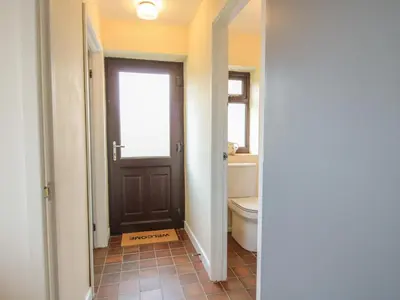 a bathroom with a brown door and a toilet at The Firs in Shrewsbury