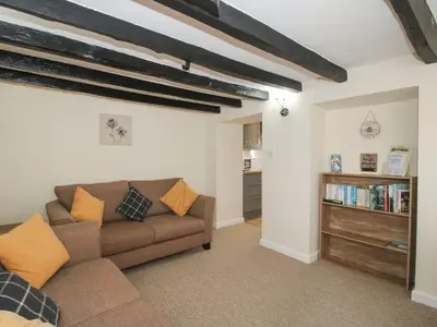 a living room with a couch and a book shelf at The Firs in Shrewsbury