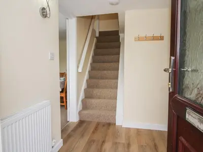 a staircase in a home with white walls and wooden floors at The Firs in Shrewsbury