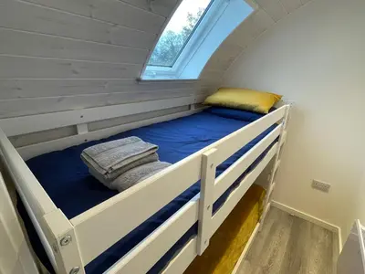 a bunk bed in a tiny house with a window at The Pod at Gerycoed in Llangadog