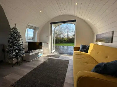 a living room with a couch and a christmas tree at The Pod at Gerycoed in Llangadog