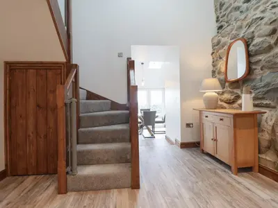 a room with a staircase and a stone wall at Gaerau Bach in Llanbedr