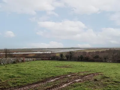 a field with a tractor tracks in the grass at Gaerau Bach in Llanbedr