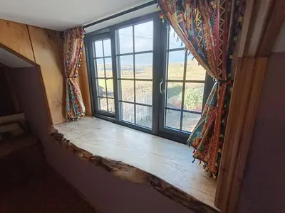 a window in a room with a wooden window sill at A peaceful cottage in the countryside in Abermule