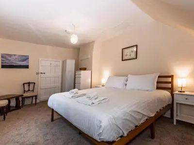a bedroom with a bed with white sheets and a desk at Spacious home sleeps 9 - walker cyclist retreat - Pass the Keys in Church Stretton