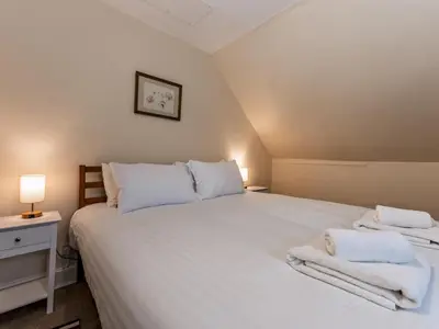 a bedroom with a large white bed with towels on it at Spacious home sleeps 9 - walker cyclist retreat - Pass the Keys in Church Stretton