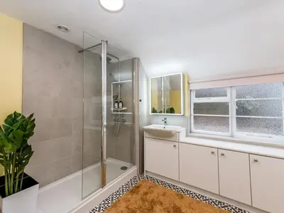 a bathroom with a shower and a sink and a mirror at Spacious home sleeps 9 - walker cyclist retreat - Pass the Keys in Church Stretton