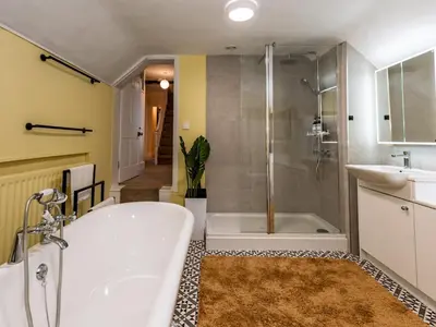 a bathroom with a tub and a shower and a sink at Spacious home sleeps 9 - walker cyclist retreat - Pass the Keys in Church Stretton