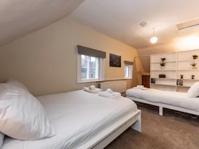 a bedroom with two beds and a window at Spacious home sleeps 9 - walker cyclist retreat - Pass the Keys in Church Stretton