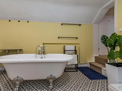 a bathroom with a large white tub in a room at Spacious home sleeps 9 - walker cyclist retreat - Pass the Keys in Church Stretton
