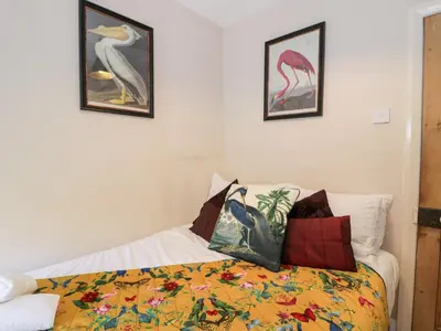 a bedroom with a bed with a colorful blanket at Glandwr Cottage in Llanbedr