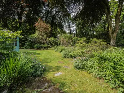 a garden with flowers and plants in the grass at Glandwr Cottage in Llanbedr