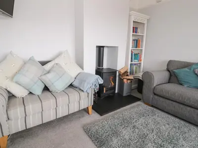 a living room with a couch and a stove at Glynmor in Harlech