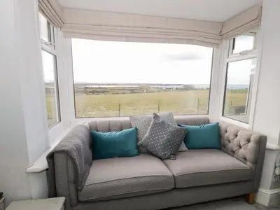 a couch in a room with two windows at Glynmor in Harlech