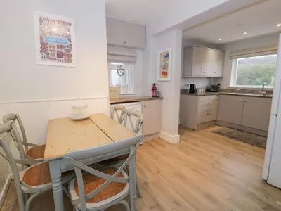 a kitchen with a table and chairs in a room at Glynmor in Harlech