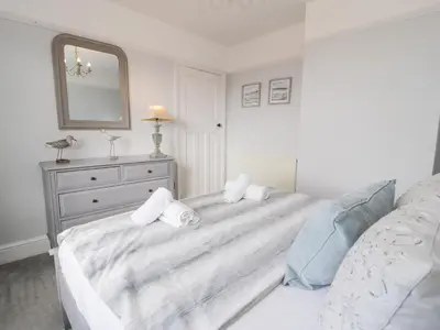 a bedroom with a bed with a mirror and a dresser at Glynmor in Harlech