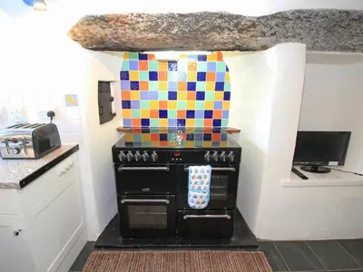 a kitchen with a stove with a colorful at The Farmhouse in Llanbedr