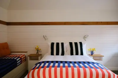 a bedroom with a bed with striped pillows and a couch at The Bridges in Shrewsbury