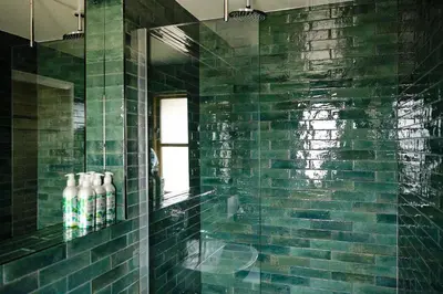 a green tiled bathroom with a sink and a mirror at The Bridges in Shrewsbury