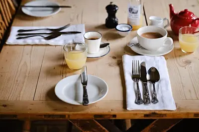 a wooden table with plates and utensils on it at The Bridges in Shrewsbury