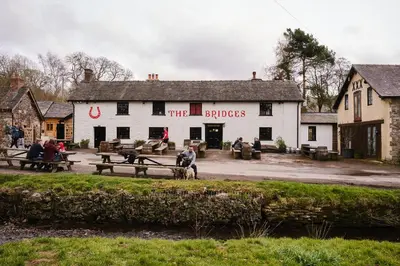 a pub with people sitting on benches in front of it at The Bridges in Shrewsbury