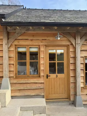 a log cabin with a wooden door and windows at The Bridges in Shrewsbury