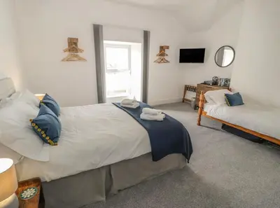 a bedroom with a large bed and a couch at Sandpiper Apartment in Barmouth
