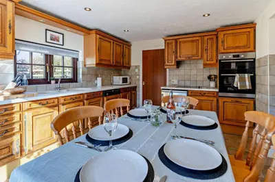 a kitchen with a table with white plates on it at 3 Bed in Pentre Bach oc-t30863 in Pentre-bâch
