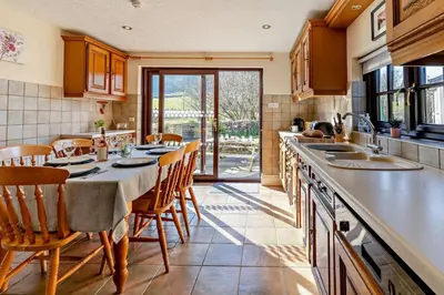 a kitchen with a table and some chairs and a counter at 3 Bed in Pentre Bach oc-t30863 in Pentre-bâch