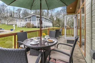 a table and chairs on a porch with an umbrella at 2 Bed in Gilfachrheda oc-b30905 in Llanina