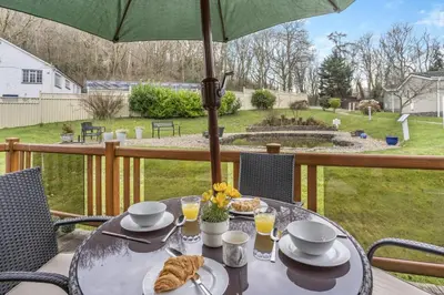 a table with an umbrella and some food on it at 2 Bed in Gilfachrheda oc-b30905 in Llanina