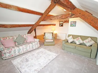 a living room with two couches and a chair at Y Stabl The Old Stable in Llanbedr