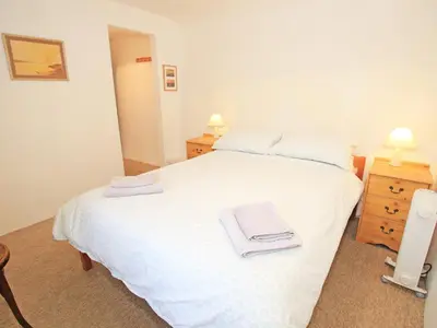 a bedroom with a white bed with towels on it at Y Stabl The Old Stable in Llanbedr