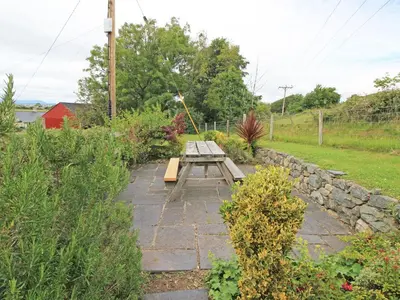 a picnic table in the middle of a garden at Y Stabl The Old Stable in Llanbedr