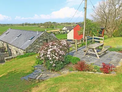 a bench sitting on a stone walkway next to a house at Y Stabl The Old Stable in Llanbedr